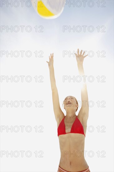 Young woman throwing beach ball in air. Date : 2008