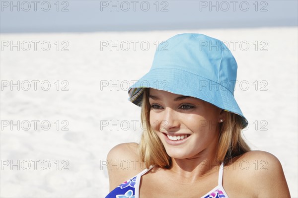 Teenage girl in hat sunbathing on beach. Date : 2008