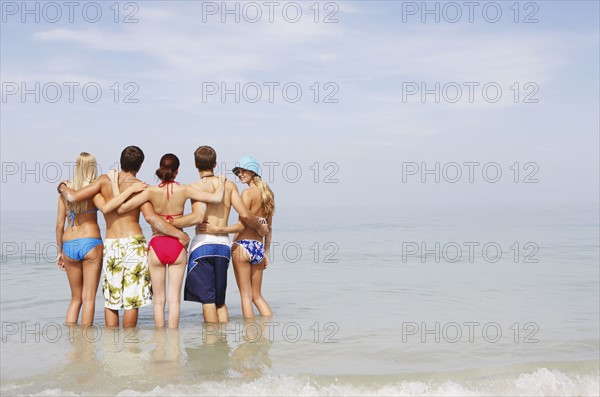 Friends hugging and standing in ocean. Date : 2008