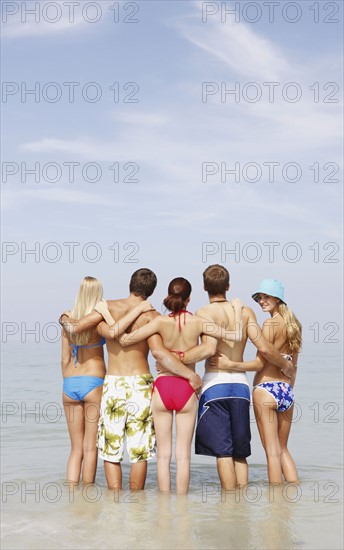 Friends hugging and standing in ocean. Date : 2008