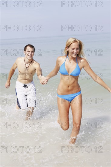 Young couple running in ocean. Date : 2008