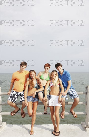 Friends posing on boardwalk railing. Date : 2008