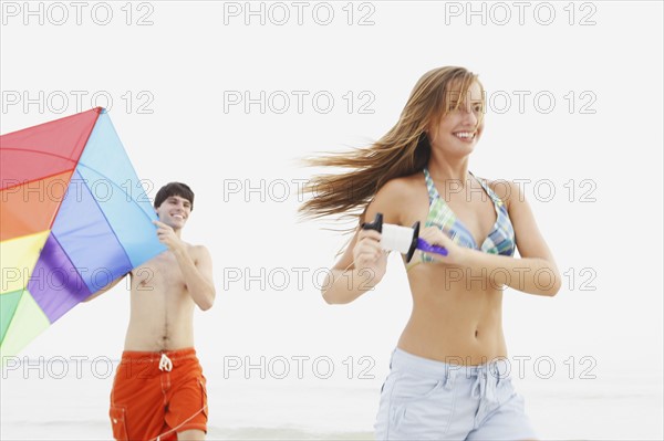 Friends flying kite on beach. Date : 2008