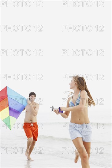 Friends flying kite on beach. Date : 2008