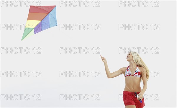 Young woman flying kite on beach. Date : 2008