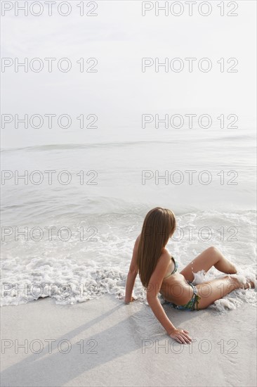 Teenage girl sitting in ocean. Date : 2008