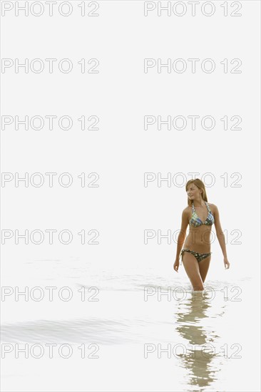 Teenage girl wading in ocean. Date : 2008