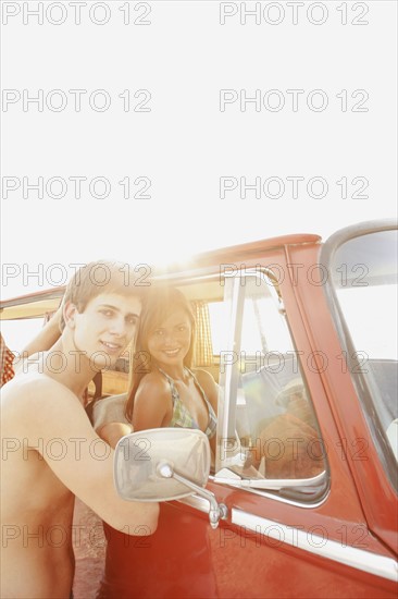 Teenage couple relaxing in van on beach. Date : 2008