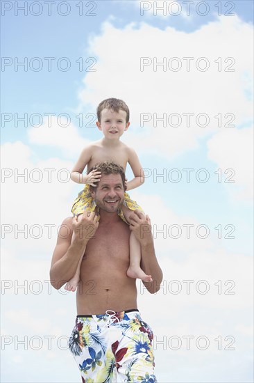 Father carrying son on shoulders. Date : 2008