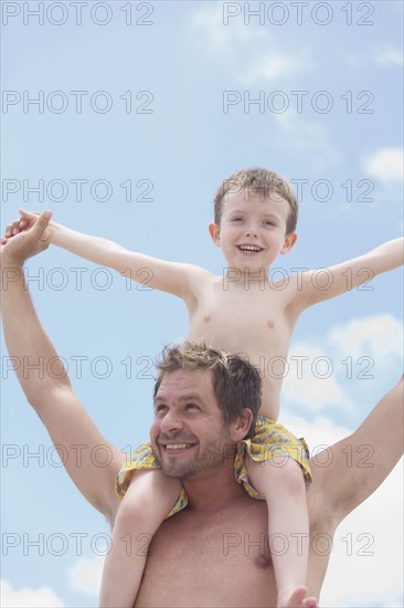 Father carrying son on shoulders. Date : 2008