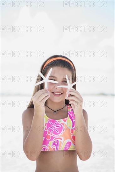 Girl on beach holding delicate starfish. Date : 2008