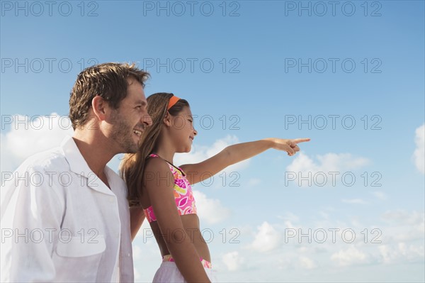 Father and daughter looking out to sea. Date : 2008