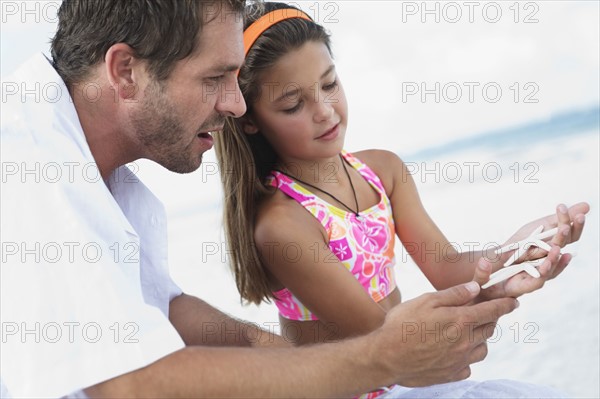 Daughter showing starfish to father. Date : 2008