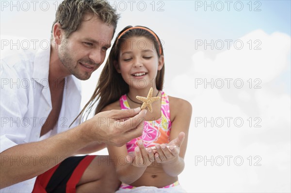 Daughter showing starfish to father. Date : 2008