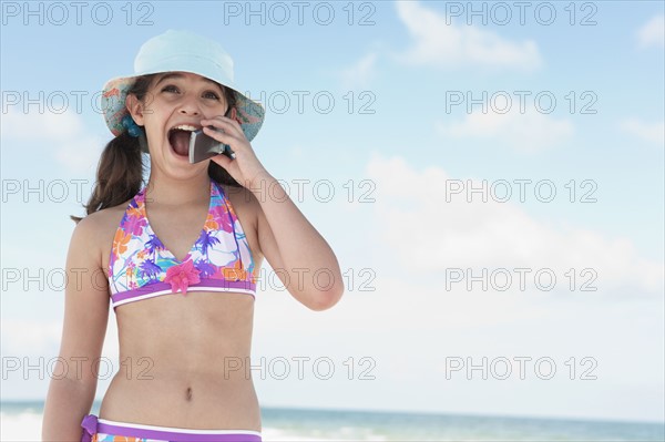 Girl on beach talking on cell phone. Date : 2008