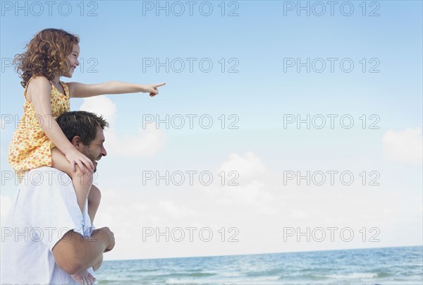 Father carrying daughter on shoulders. Date : 2008