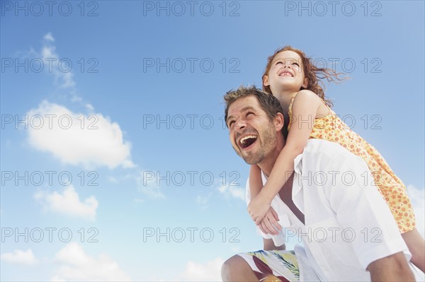 Father carrying daughter on shoulders. Date : 2008