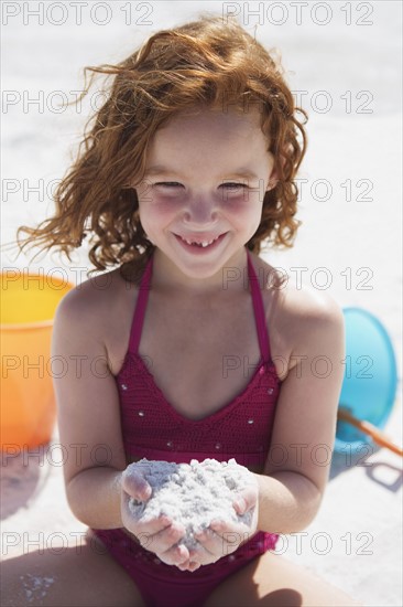 Girl digging in sand on beach. Date : 2008