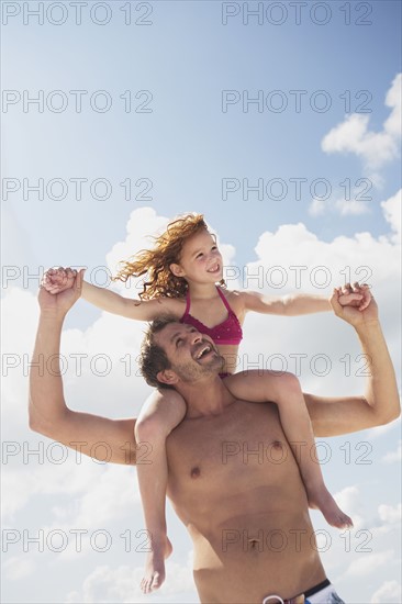 Father carrying daughter in shoulders. Date : 2008