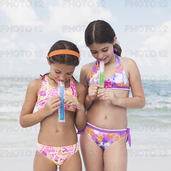 Girls eating ice pops on beach. Date : 2008