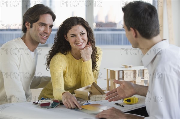 Architect presenting plans to couple.