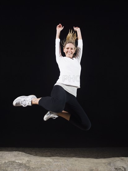 Portrait of woman jumping above driftwood. Date: 2008