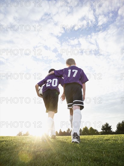 Boys in soccer uniforms walking on field. Date: 2008