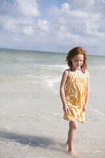 Girl walking through ocean surf. Date : 2008