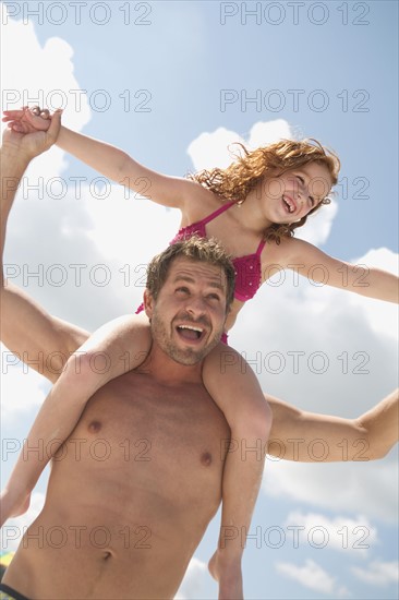 Father carrying daughter on shoulders. Date : 2008