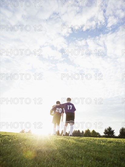 Boys in soccer uniforms walking on field. Date : 2008