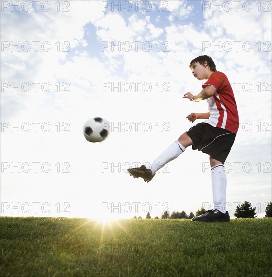 Boy in uniform kicking soccer ball. Date: 2008