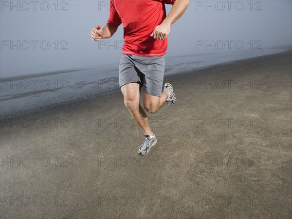 Man jogging on foggy beach. Date : 2008