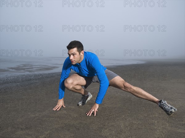 Man stretching on foggy beach. Date : 2008