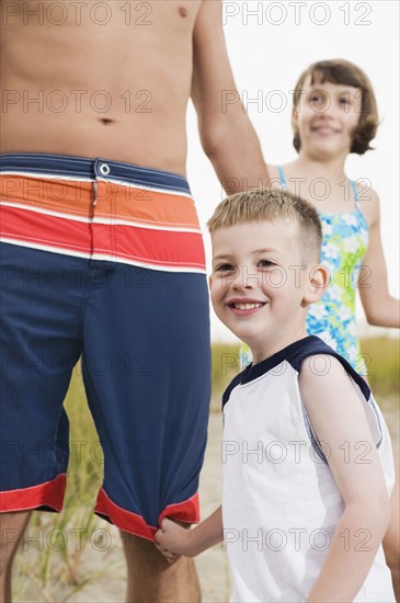 Father, daughter, and son on beach. Date : 2008