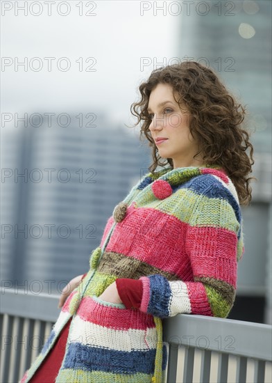 Woman leaning against railing.