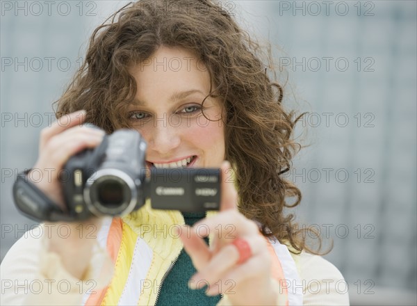 Close up of woman using video camera.