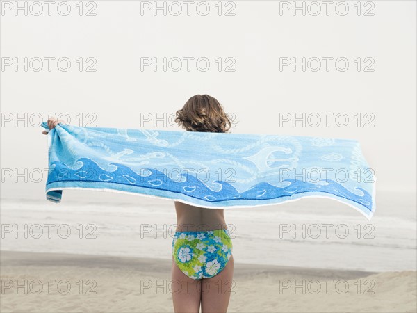 Girl holding towel on beach. Date : 2008