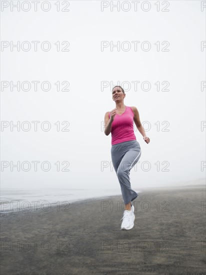 Woman jogging on foggy beach. Date: 2008