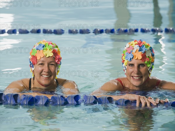 Women in swim caps posing in swimming pool. Date : 2008