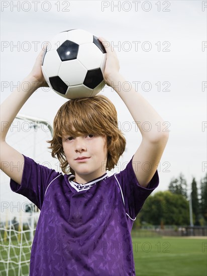 Portrait of boy holding soccer ball on head. Date : 2008