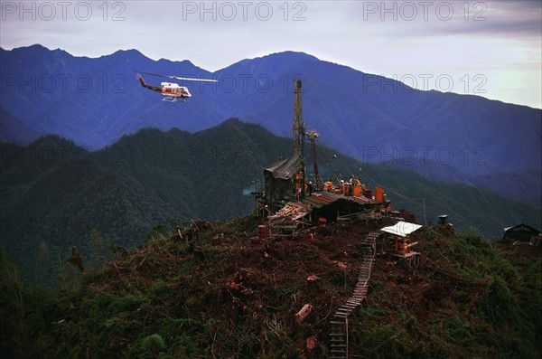 Helicopter flying over oil drilling platform in Indonesia. Date: 2008