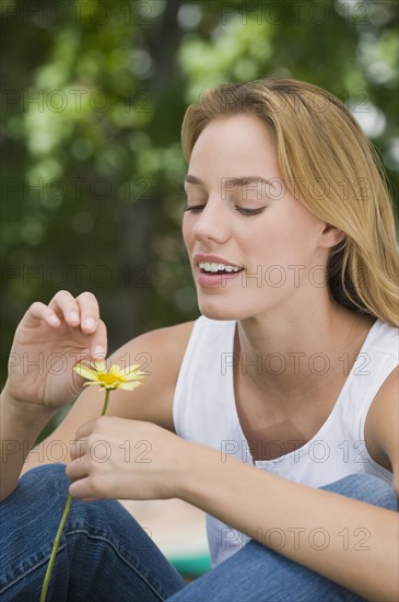 Woman picking petals off flower.
