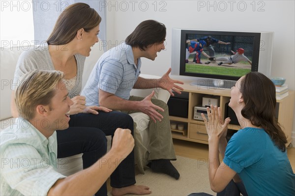 Friends watching baseball game and cheering.