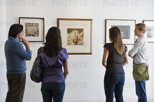 People looking at pictures in art gallery.