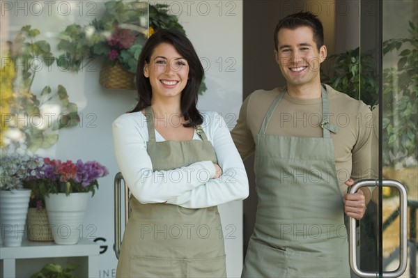 Man and woman standing in doorway of flower shop.