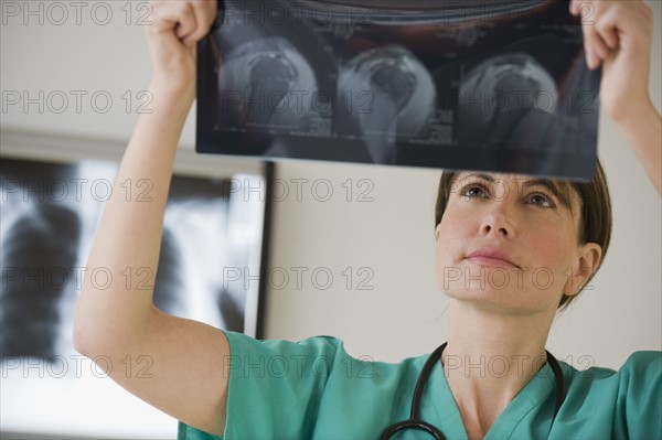 Female technician examining x-ray.