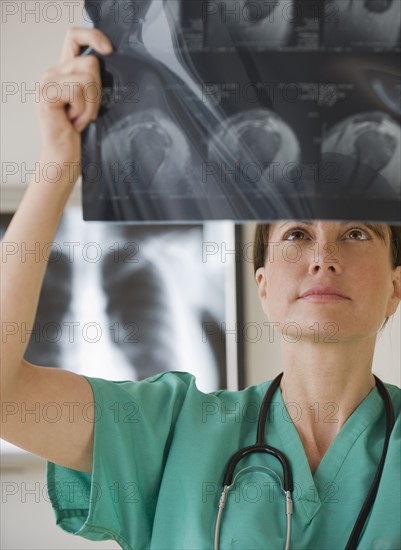 Female technician examining x-ray.