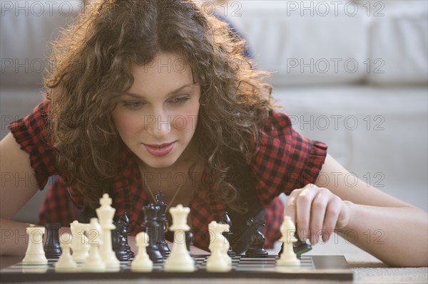 Woman moving chess piece.