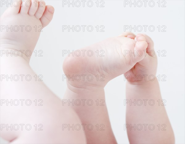 Close up of baby grabbing feet. Date : 2008