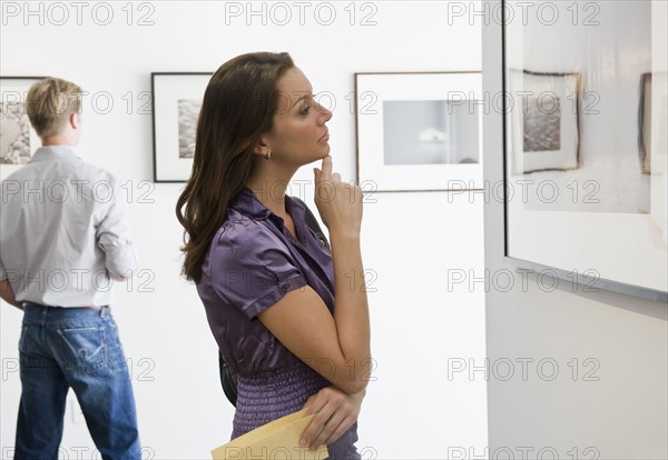 Woman looking at picture in art gallery.